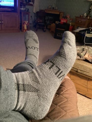 Reviewer relaxing with their feet up while wearing the grey Men's Alpaca Socks.
