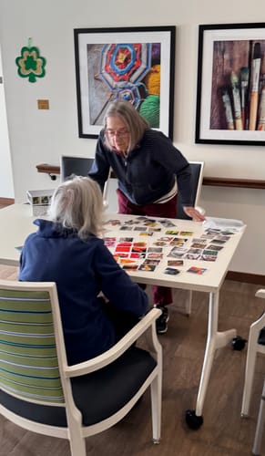 Customer and another person looking at a large set of OuiSi Original photo cards spread across a table.