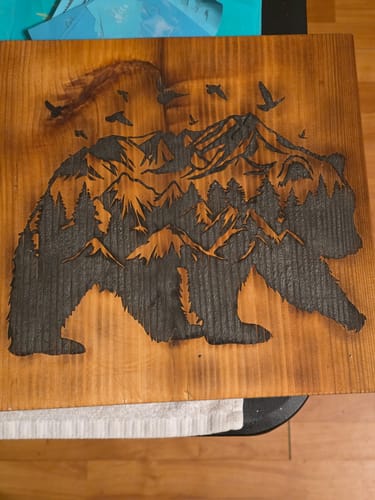Customer's wood art of a bear with a detailed mountain scene inside, created with Wood Pre-Treatment for crisp lines.