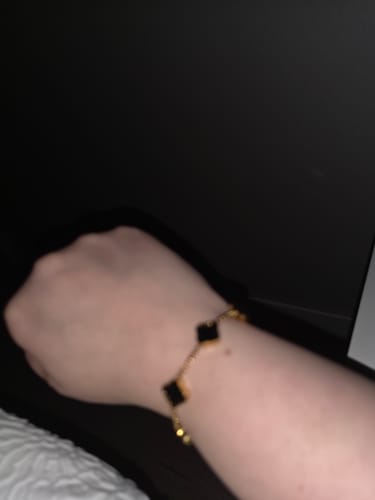 Close-up of a reviewer showing a bracelet on their wrist in a review for Shipping Insurance.