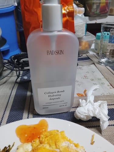 Customer's large Bad Skin Korean Collagen Bomb Hydrating Ampoule bottle on a dining table.