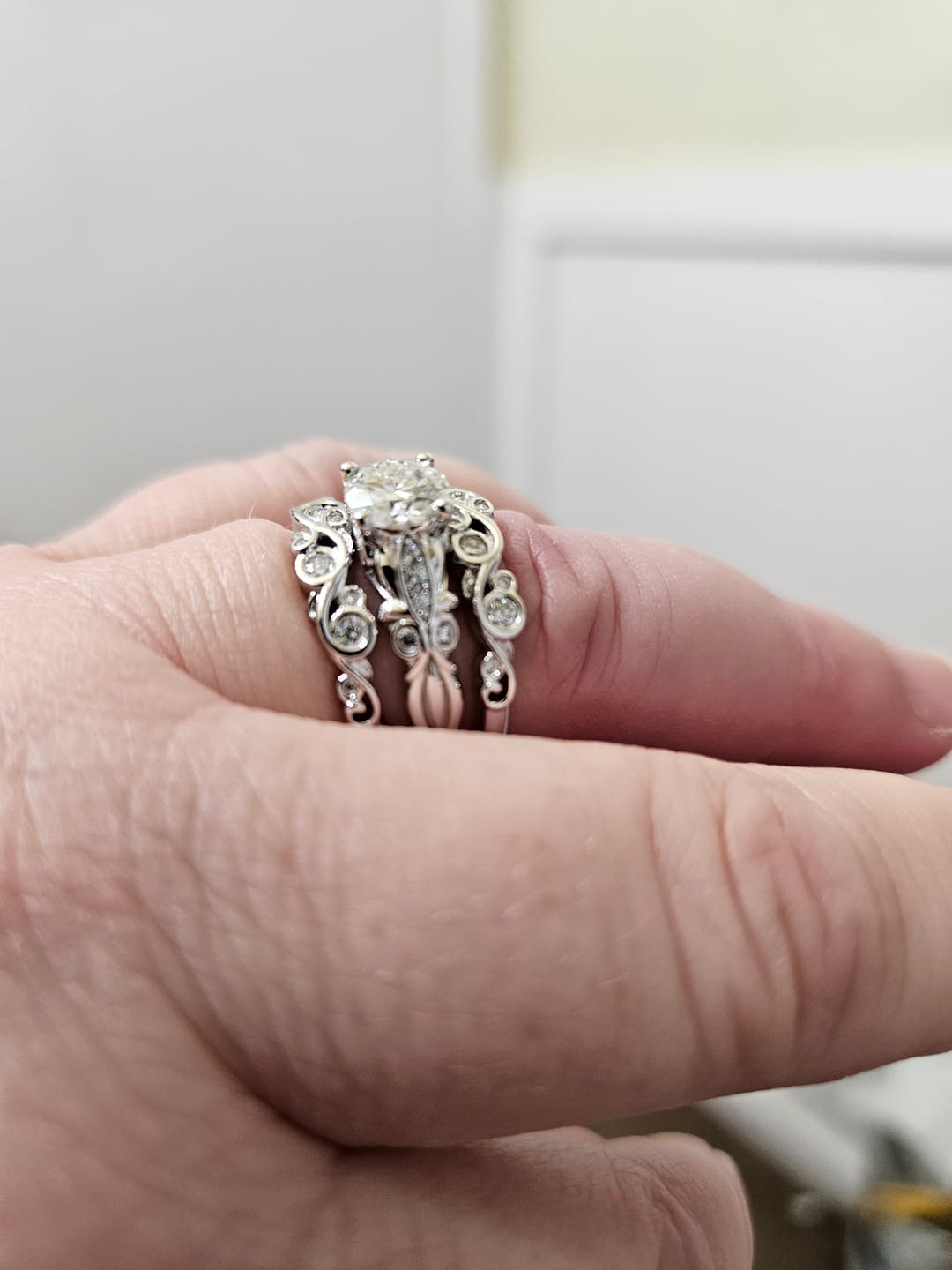 Customer photo review of Bezel Set Round Moissanite Scroll Accents Wedding Band Ring In Sterling Silver