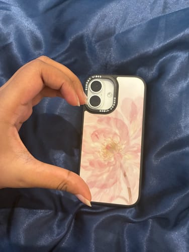 Customer holding the Pale Peony iPhone Case against a shiny blue background.