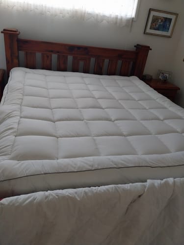 Customer's puffy, quilted Luxury Mattress Topper shown on a bed.