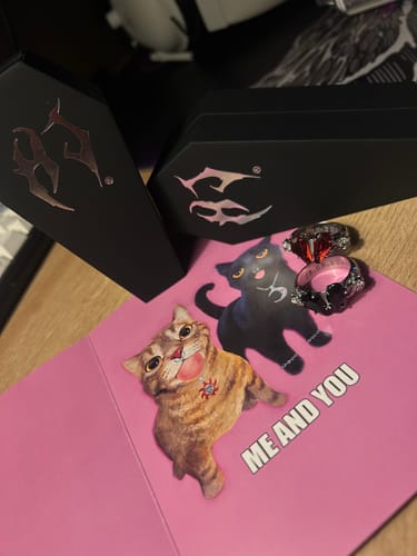 Customer's upgraded packaging, featuring two black coffin-shaped boxes shown with rings and a card.