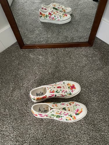 Reviewer's white floral shoes on a gray carpet, with their reflection visible in a mirror above.