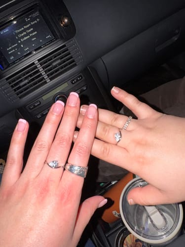 Customer and a friend showing off their matching Pia Rings with pear-cut stones in a car.