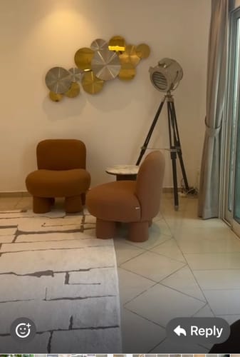 Customer's handcrafted stainless steel artwork with gold and silver brushed discs mounted on a living room wall.