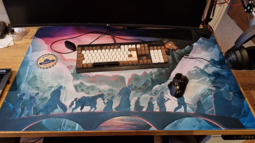 Customer's large custom iD Mammoth mousepad with a fantasy scene print, shown on a desk with a keyboard and mouse.