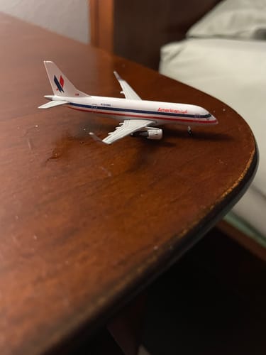 Reviewer's American Eagle E170 model plane in its heritage livery resting on a wooden table.