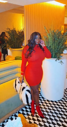 Reviewer posing indoors in the red Stretch Lace Scallop Mini Dress, showing its bodycon fit.
