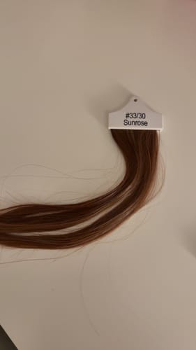 Customer's Heat Resistant Colour Sample in Sunrose (#33/30) lying on a neutral surface showing its rich auburn tones.