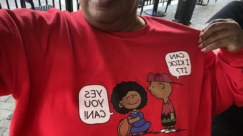 Customer wearing their red 'Can I Kick It? Sweatshirt' and showing the cartoon graphic on the front.