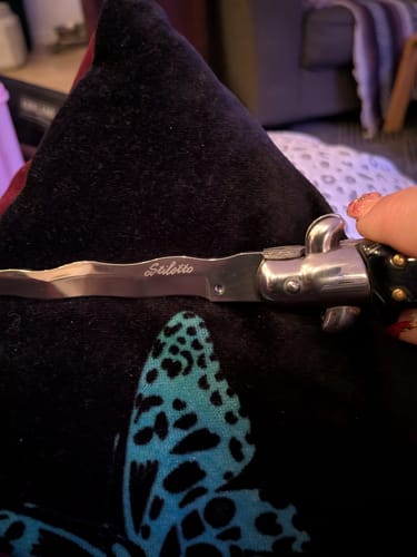 Reviewer holding the Kriss Blade Italian Stiletto, showing a close-up of the open wavy blade and handle.