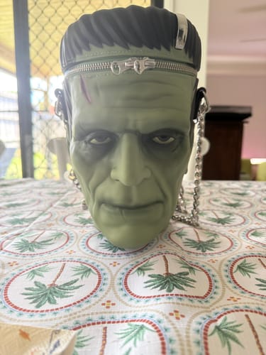 Customer's Frankenstein Monster Crossbody Bag on a table, showing the detailed molded face and silver chain.