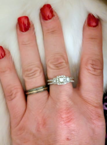 Close-up of a reviewer's hand wearing the hammered, rose gold Gladiator ring next to a diamond ring.