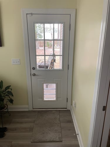 Customer's white door with the Clear 9 Lite Glass and Frame Kit installed, seen from inside a hallway.