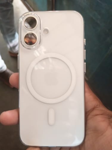 Reviewer holding a white phone in a clear case with a visible magnetic ring.