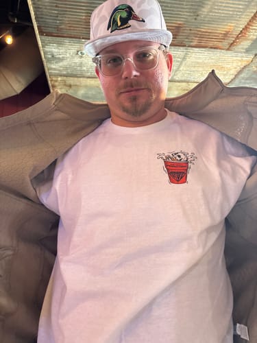 Reviewer wearing the white BALLS DEEP TEE with a small chest graphic under an open jacket.