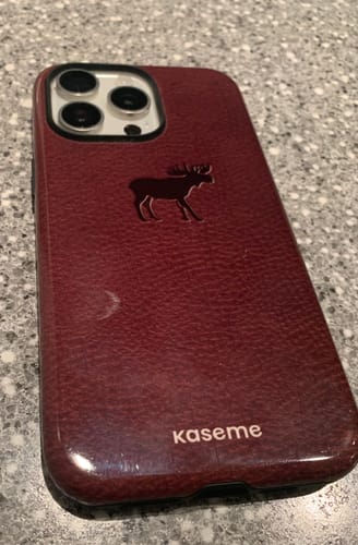 Customer's burgundy Nordik phone case with a moose design, showing its raised camera protection.