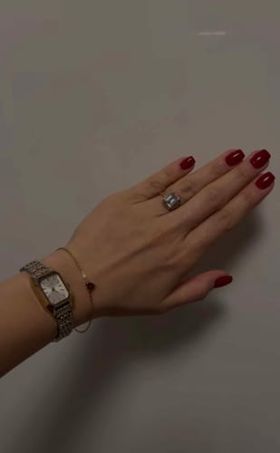 A reviewer wears the Isabell Petite Gold Silver watch on their wrist, highlighting its elegant two-tone band.