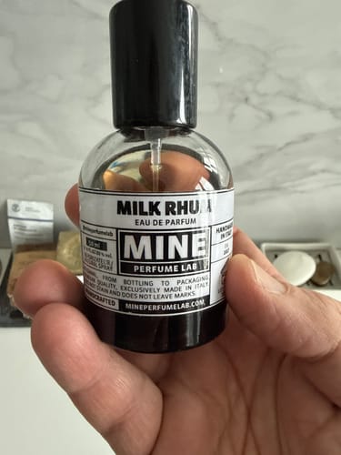 Recensore che tiene in mano la piccola boccetta del profumo MILK RHUM.