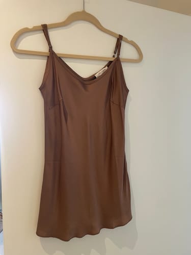 Customer shows the matching satin vest on a hanger in a review for the Camilla Bias Satin Skirt.