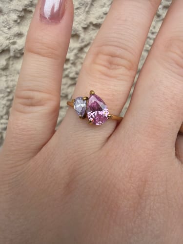 Customer showing the Leesha Birthstone Ring on their hand, featuring one large pink and one smaller light purple pear-cut stone.
