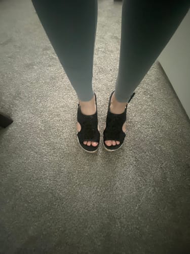Reviewer's top-down view of the Corky's Black Mesh Carley Sandals being worn indoors.