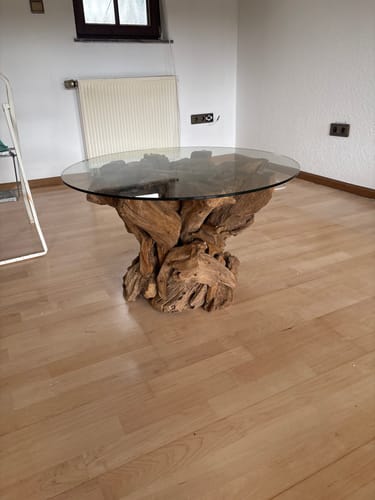 Kunde zeigt den aufgebauten IKAL Couchtisch aus Wurzelholz mit Glasplatte in seinem Zimmer.