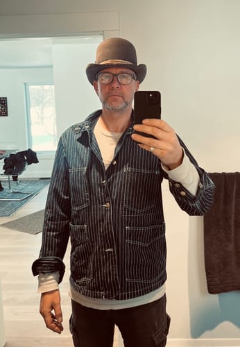 Reviewer wearing the striped Wabash Railway Work Coat. The size medium coat is layered over a long-sleeve shirt.