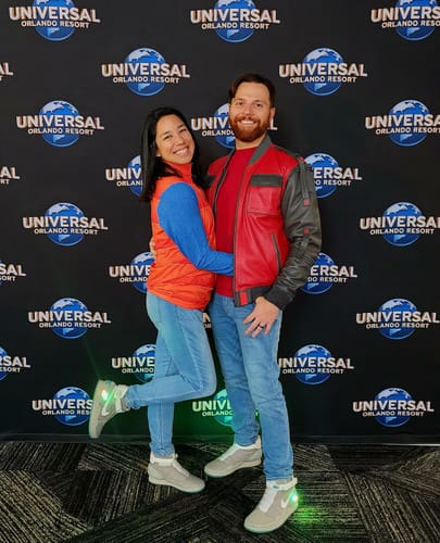 Reviewer happily posing in 'The Marty' Quarter Zip with a companion in front of a Universal Resort backdrop.