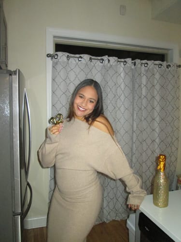 Reviewer smiling while wearing the beige Knit Off-Shoulder Sweater Maxi Dress indoors.