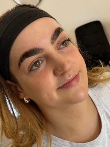 Reviewer's close-up photo of a client with flawless, laminated brows after using the Cysteamine lamination kit.