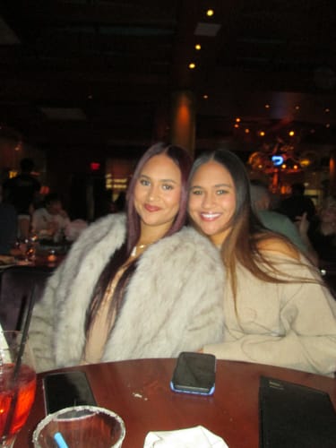 Reviewer wearing the Knit Off-Shoulder Sweater Maxi Dress while seated at a restaurant.