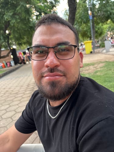 Primer plano de un cliente usando la Cadena Miami Cuban 5mm con una camiseta negra en un parque.