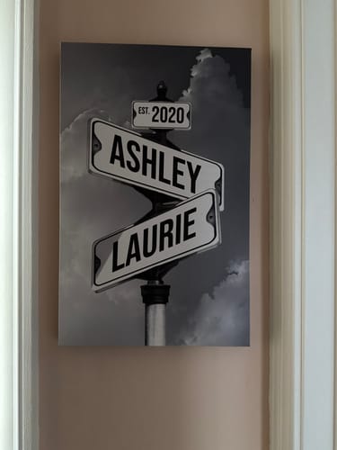 Customer's personalized 'Couples Date of Love' canvas showing street signs with the names 'Ashley' and 'Laurie' and 'EST. 2020'.