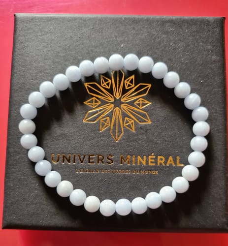 Le bracelet Angélite d'un client, avec ses perles bleu clair, posé sur sa boîte noire.