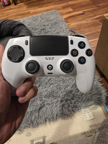 Customer holding the white Wireless Game Controller, showing its ergonomic design and button layout.