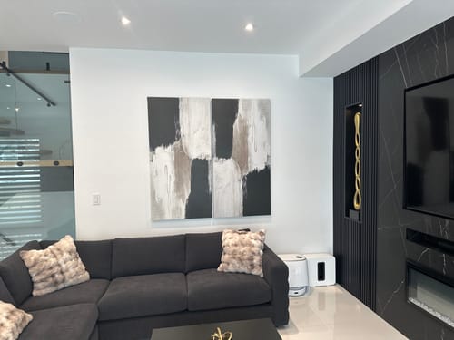 Customer's 'Boundaries' Framed Canvas hanging on a white wall above a dark grey sofa in a modern living room.