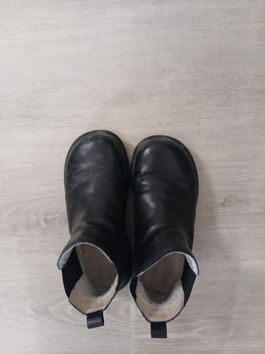A customer's pair of black fleece-lined ankle boots, seen from above, showing the soft interior lining.