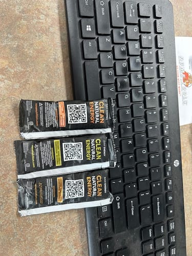 Customer's three SuperCharged Honey packets from the variety pack arranged on a desk next to a keyboard.