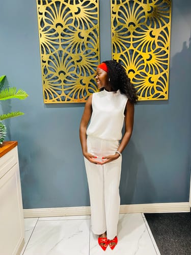 Reviewer wearing the white sleeveless tank top and trousers set, showing the full-length fit of the trousers indoors.