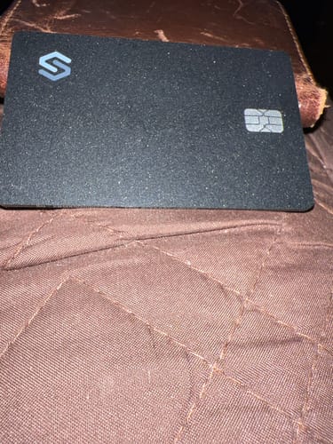 Customer's black Spotminders Tracking Card PRO with a textured finish shown on a brown surface.