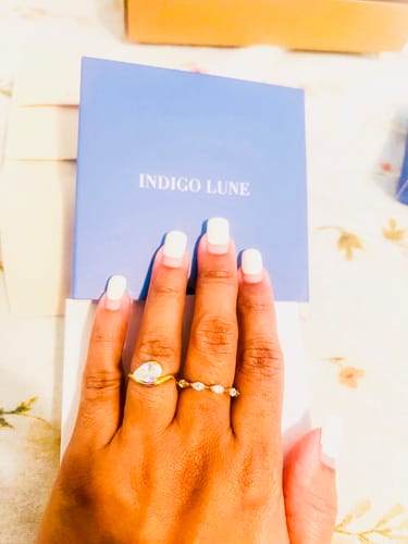 Customer's hand showing the Pia Ring with a pear-cut stone worn on the pinky finger.
