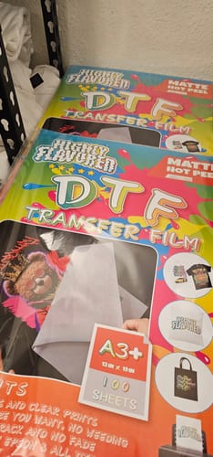 Customer shows several packages of Highly Flavored DTF transfer film for their printing setup.
