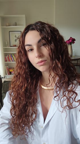 Une cliente montre ses longues boucles bien définies grâce au Coffret Routine Curl Keeper.