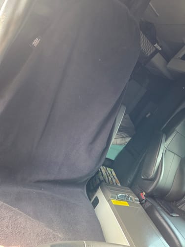 Reviewer's black Waterproof Car Towel Seat Cover fitted onto a car's front seat.