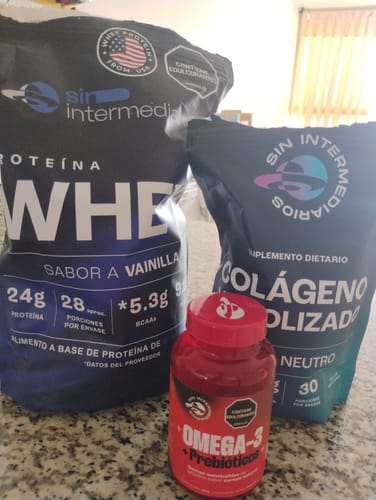 Cliente muestra el Colágeno Hidrolizado en empaque negro, junto a otros dos suplementos sobre una encimera.