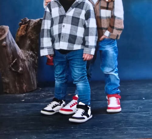 Kunde zeigt zwei Kinder, die die niedlichen Kinder Wonderland I Lite Barfußschuhe in Schwarz und Rot tragen.